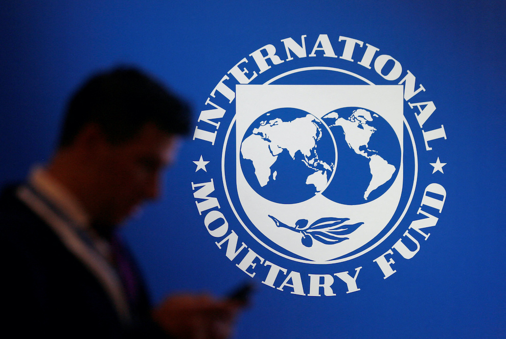 FILE PHOTO: A participant stands near a logo of IMF at the International Monetary Fund - World Bank Annual Meeting 2018 in Nusa Dua, Bali, Indonesia, October 12, 2018. REUTERS/Johannes P. Christo